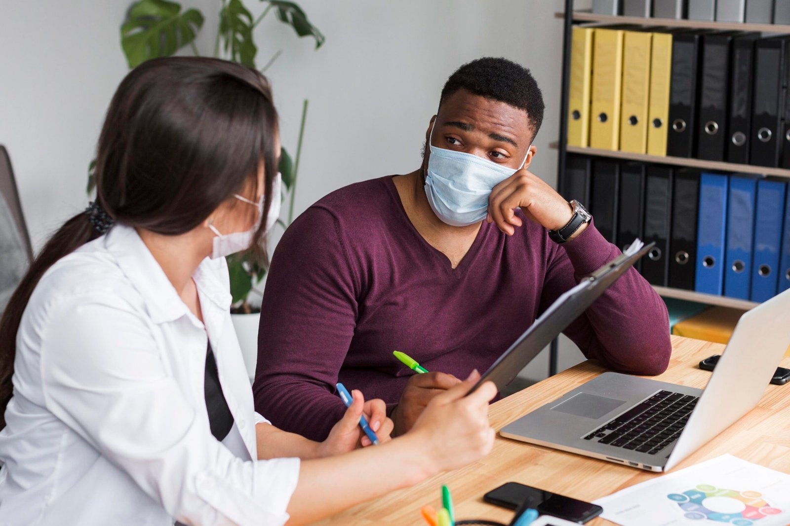 two-people-office-working-together-pandemic-with-medical-masks